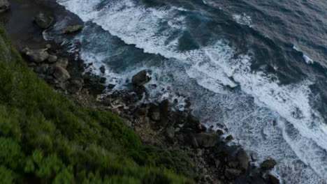 Drone-Shot-Flying-Over-Cliff-Edge-Looking-at-Waves-