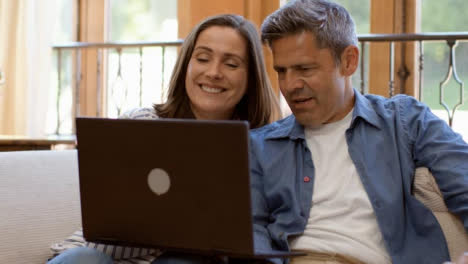 Tracking-Shot-Past-Foreground-Revealing-Middle-Aged-Couple-On-Video-Call