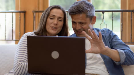 Tracking-Shot-Orbiting-Around-Middle-Aged-Couple-Using-Laptop-for-Video-Call