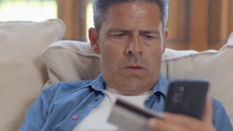 Close-Up-Shot-of-Middle-Aged-Man-Using-Smartphone-to-Make-Online-Purchase