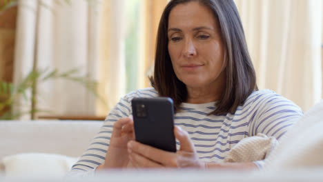 Pedestal-Shot-Revelando-Mujer-De-Mediana-Edad-Desplazándose-En-Smartphone