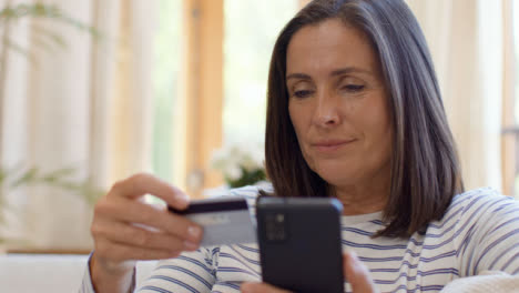 Nahaufnahme,-Die-Eine-Frau-Mittleren-Alters-Enthüllt,-Die-Das-Smartphone-Verwendet,-Um-Einen-Online-Kauf-Zu-Tätigen