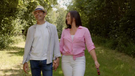Tracking-Profile-Shot-of-Middle-Aged-Couple-Walking-In-Scenic-Woodland