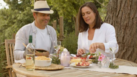 Tracking-Shot-Orbiting-Around-Middle-Aged-Couple-Enjoying-Alfresco-Dinner