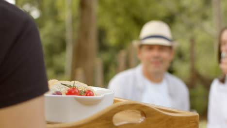 Kamerafahrt-Nach-Der-Kellnerin,-Die-Während-Des-Abendessens-Im-Freien-Brot-Zum-Paartisch-Bringt?