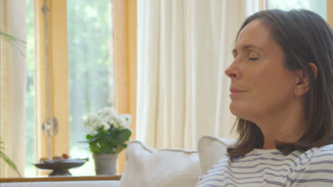 Close-Up-Shot-of-Middle-Aged-Woman-Meditating-On-Sofa