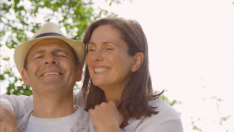 POV-Profile-Shot-of-Middle-Aged-Couple-Hugging-and-Laughing-into-the-Camera