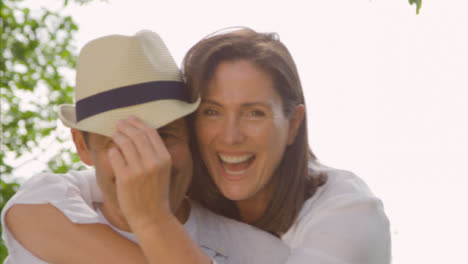 POV-Profile-Shot-of-a-Middle-Aged-Couple-Hugging-and-Laughing-into-Camera