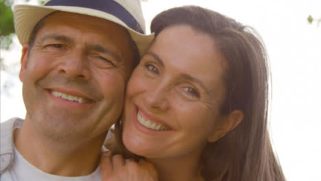 POV-Profile-Shot-of-a-Middle-Aged-Couple-Hugging-and-Laughing-into-the-Camera