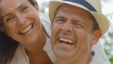 POV-Close-Up-Shot-of-a-Middle-Aged-Couple-Hugging-and-Laughing-into-the-Camera