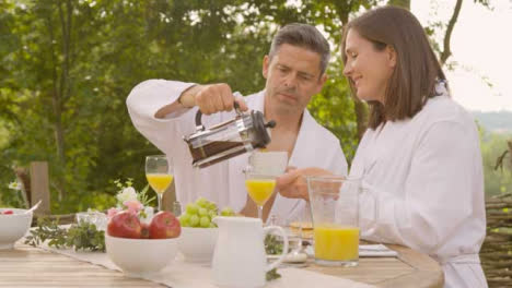 Weitwinkelaufnahme-Eines-Mannes-Mittleren-Alters,-Der-Seiner-Frau-Beim-Frühstück-Kaffee-Einschenkt