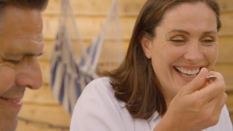 Close-Up-Shot-of-Middle-Aged-Woman-Eating-Yoghurt-and-Talking-to-Husband-at-Breakfast