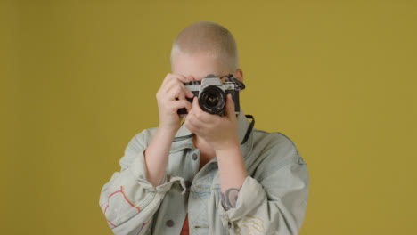 Portrait-Shot-of-Model-Using-Retro-SLR-Camera-and-Smiling-to-Camera