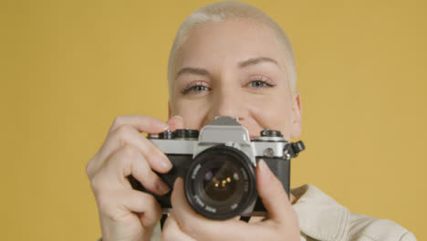 CU-Smiling-Woman-Takes-Photographs-on-Vintage-Camera