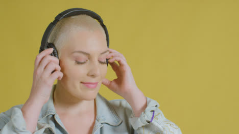 Female-caucasian-model-listening-to-music-on-headphones-studio-portrait-01