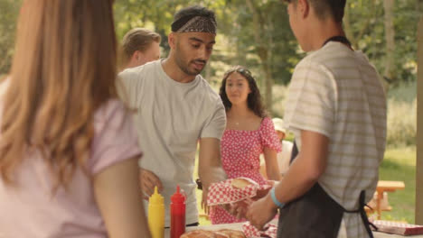 Long-Shot-of-Festival-Goer-Getting-a-Hot-Dog-from-Fast-Food-Stand