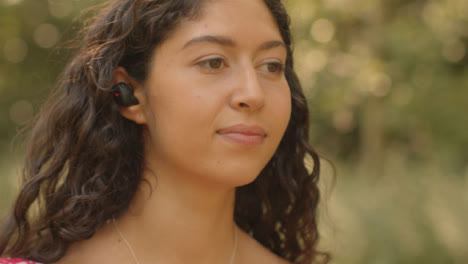 Close-Up-Shot-of-Young-Woman-Listening-to-Music-Through-Wirless-Earphones