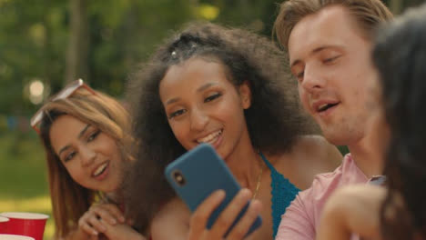 Close-Up-Shot-of-Group-of-Young-Friends-Laughing-at-Something-On-Smartphone