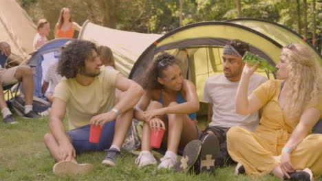 Sliding-Shot-of-Festival-Goers-Drinking-and-Talking-by-Their-Tent