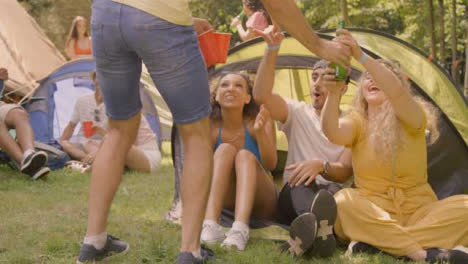 Sliding-Shot-of-Young-Festival-Goer-Bringing-His-Friends-Some-Alcoholic-Drinks