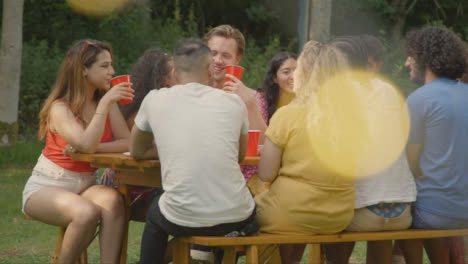 Long-Shot-of-Friends-Sitting-Around-a-Outdoor-Table-Laughing-and-Talking