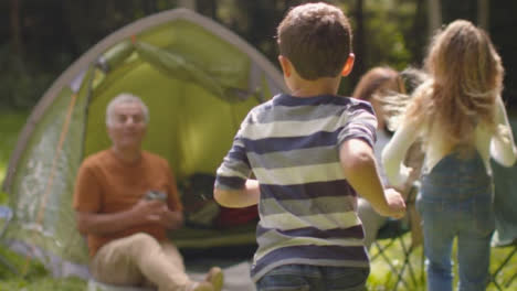 Tracking-Shot-Following-Young-Children-Running-to-Their-Grandparents-On-Camping-Trip