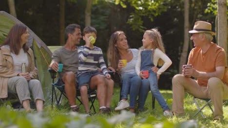 Long-Shot-of-Family-On-Camping-Trip-Sitting-By-Their-Tents-01