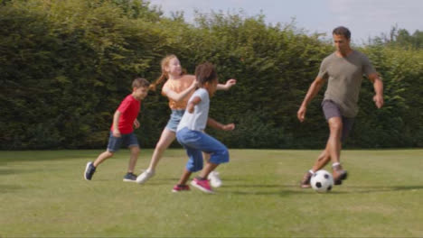 Seguimiento-De-Disparo-De-Un-Adulto-Jugando-Al-Fútbol-Con-Un-Grupo-De-Niños-01