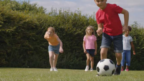 Kamerafahrt-Einer-Gruppe-Von-Kindern,-Die-Fußball-Spielen-03