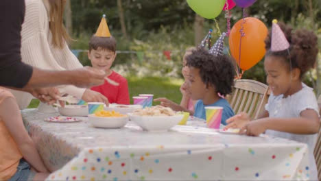 Tracking-Shot-of-Children-Sitting-at-Table-at-Outdoor-Birthday-Party-01