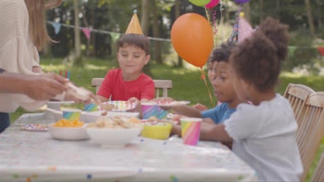 Tracking-Shot-of-Children-Sitting-at-Table-at-Outdoor-Birthday-Party-02