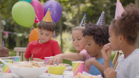 Tracking-Shot-of-Children-Sitting-at-Table-at-Outdoor-Birthday-Party-04