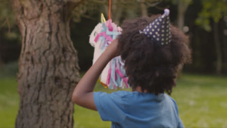 Close-Up-Shot-of-Young-Boy-Swinging-In-Wrong-Direction-of-Pinata