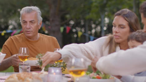 Tracking-Shot-of-Family-Serving-Up-Food-During-Outdoor-Dinner-02