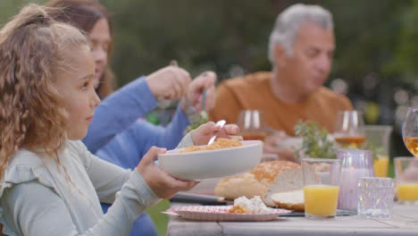 Toma-De-Seguimiento-De-La-Familia-Sirviendo-Comida-Durante-La-Cena-Al-Aire-Libre-04