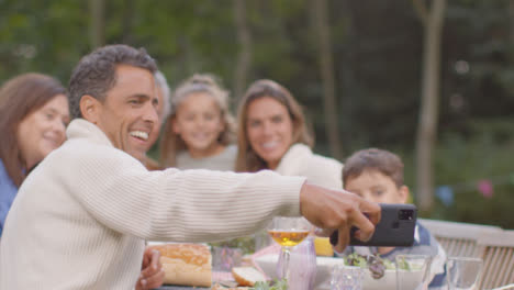 Tracking-Shot-of-Family-Taking-a-Selfie-at-Outdoor-Dinner-Table-02