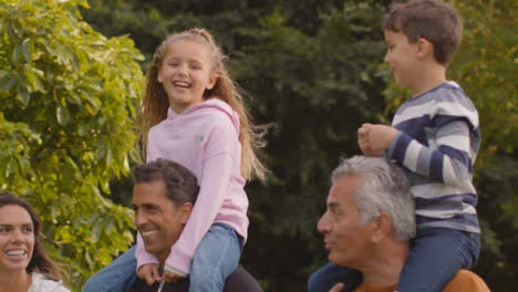 Tracking-Shot-of-Children-Sitting-On-Their-Parents-and-Grandparents-Shoulders-03