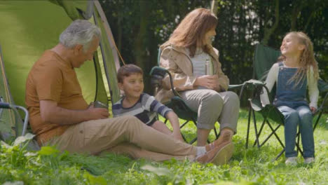 Low-Angle-Shot-of-Grandchildren-Joining-Their-Grandparents-by-Their-Tents