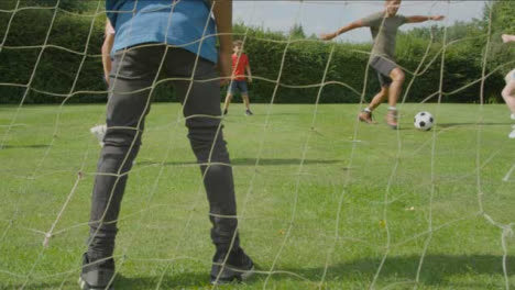 Handheld-Shot-Goal-Net-as-Children-Play-Football