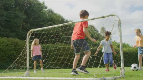 Low-Angle-Shot-Behind-Goal-Net-of-Children-Playing-Football-01