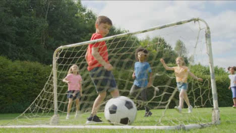 Low-Angle-Shot-Hinter-Dem-Tornetz-Von-Kindern,-Die-Fußball-Spielen-02