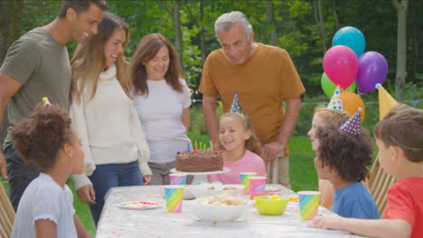 Handaufnahme-Einer-Familie,-Die-Das-Kind-Klatscht,-Nachdem-Sie-Kerzen-Auf-Dem-Geburtstagskuchen-Ausgeblasen-Hat