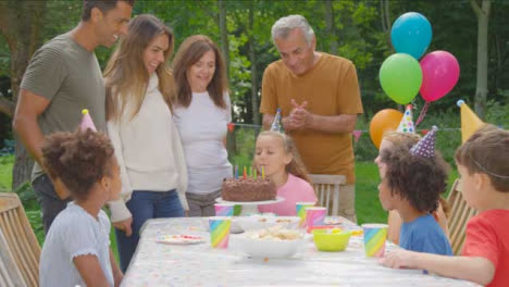 Handheld-Shot-of-Family-Singing-Happy-Birthday-to-Young-Girl