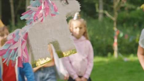 Handheld-Shot-of-Young-Girl-Hitting-Pinata-at-Birthday-Party-01