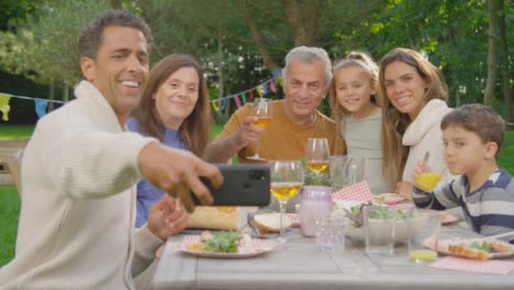 Handheld-Shot-of-Family-Taking-Selfie-During-Al-Fresco-Dinner-01