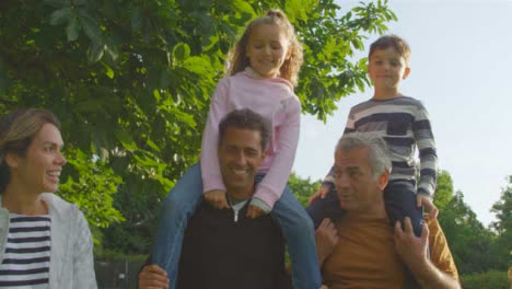 Low-Angle-Shot-of-Children-Riding-On-Their-Family's-Shoulders