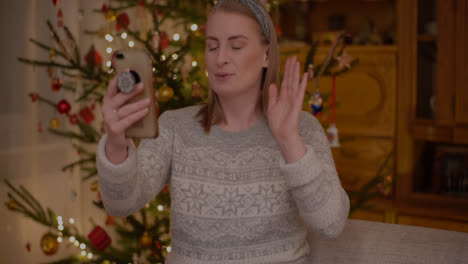 Positive-Frau-Videochatten-Weihnachts-Smartphone