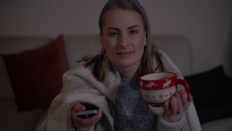 Woman-Covered-With-Warm-Blanket-Watching-Tv-In-Living-Room-At-Christmas-1