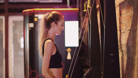 Side-View-Of-Confident-Young-Woman-Exercising-On-Cable-Machine-During-Fitness-Training