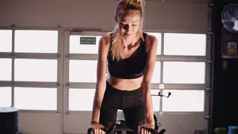 Determined-Young-Woman-Cycling-On-Stationary-Bike-At-Fitness-Studio-7